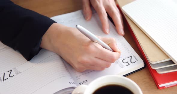 Businesswoman writing in diary