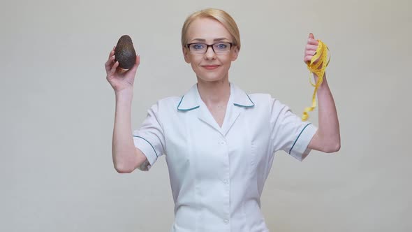Nutritionist Doctor Healthy Lifestyle Concept - Holding Organic Avocado Fruit and Measuring Tape