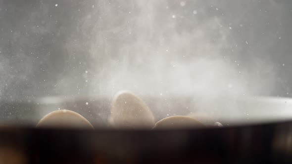 Camera follows cooking clams in a pan. Slow Motion.