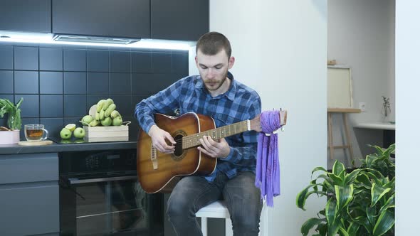 Man learning to play chords on acoustic guitar. Music concept