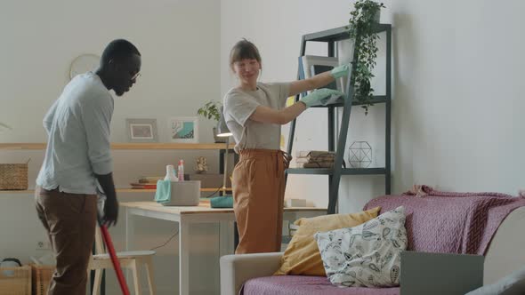 Young Multiethnic Couple Cleaning Home Together