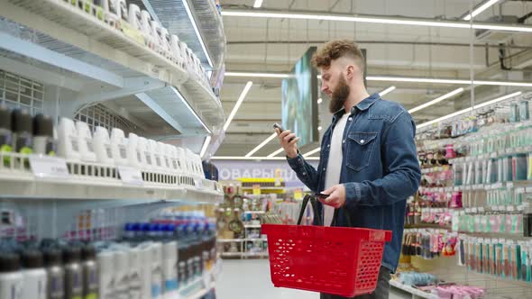 Shopping in Cosmetic Department of Supermarket Young Man is Choosing Deodorant
