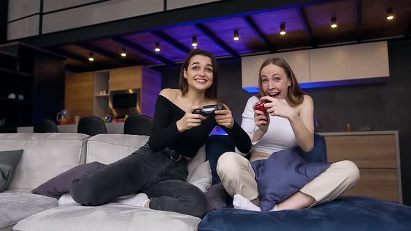 Girls which Having Fun Together while Playing Video Games and After Ending the Game Celebrate Win