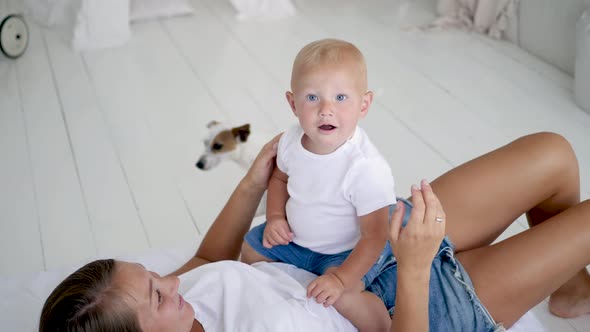 Family with Two Children Lie on a White Big Bed