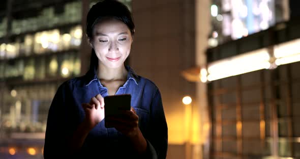 Woman using smart phone in city 