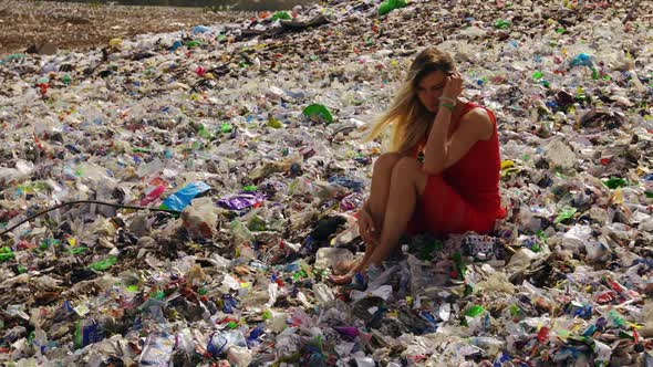 Female Nature Pollution Activist Sits at Huge Trash Dump