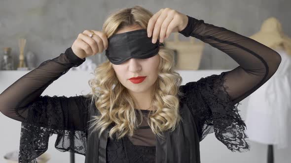 Beautiful Blond Woman with Bright Makeup Taking Off the Sleep Mask and Looking at the Camera Smiling