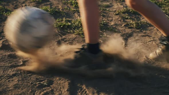 The football player scores the ball into the goal. The boy kicks the ball