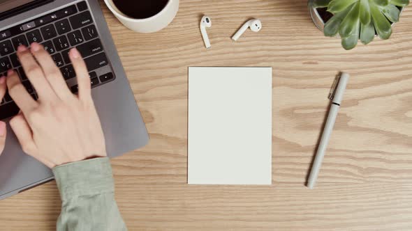 Mockup a Blank Paper Lies on the Desktop of a Young Woman