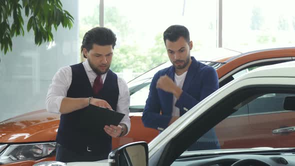 Professional Car Dealer Selling New Auto To a Young Man