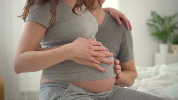 Pregnant Woman and Her Husband Holding Hand Together