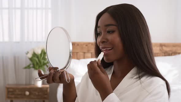 African Woman Applying Lipstick Or Lips Balm Making Makeup Indoor