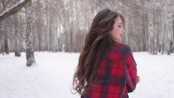 Female in Checkered Shirt Walking in Snowy Park