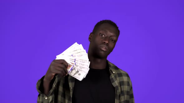 Happy African American Man Holding Hundred Dollar Banknotes Fan Nodding Head and Looking at Camera