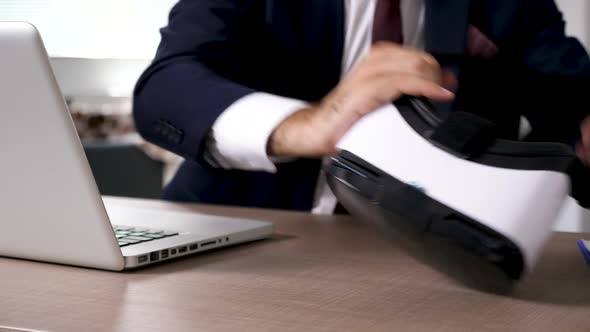 Close Up Businessman Types on Computer Than Picks Up a VR Headset