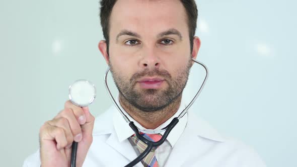 Doctor Sitting in Clinic with Stethoscope in Ears
