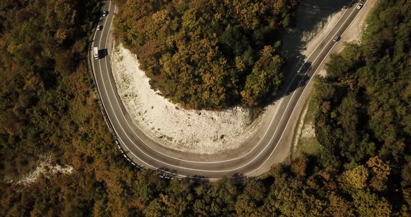 Aerial View of Car Driving Along The Winding Mountain Pass Road Through The Forest Trees. Autumn