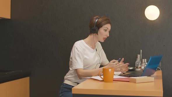 Confident Young Businesswoman in Headphones Using Virtual Conference for Remote Work. Side View