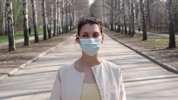 Young Girl in Medical Mask, Being Outdoors During Quarantine During Pandemic Covid-19, Looking at