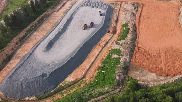 Aerial View of a Tractor Dump Trucks and a Large Pile of Granite Rubble