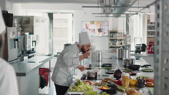 Male Cook Doing Taste Test with Delicious Sauce on Stove