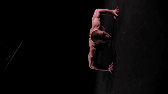 Young Pumped Man Training His Hands with Push Ups in the Dark Arena