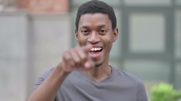 Portrait of Cheerful Young African Man Pointing at the Camera