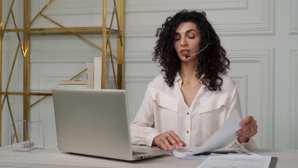 Smiling Indian Employee with Curly Hair in Headphones Talks Via Video Link Holds a Web Conference