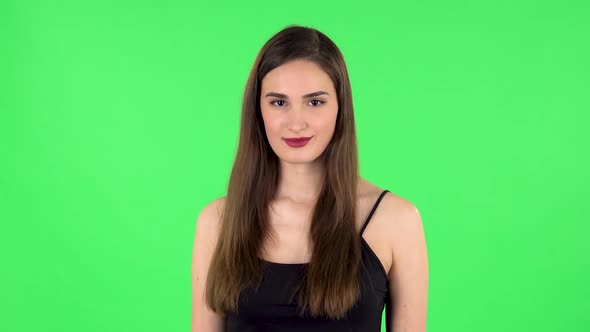 Female Listens Attentively and Nods His Head Pointing Finger at Viewer. Green Screen