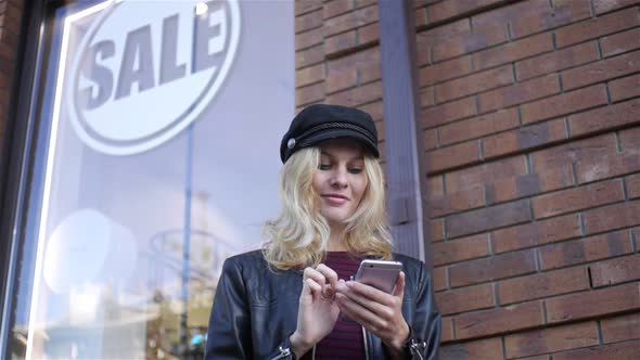 slow-motion, woman with phone down the street