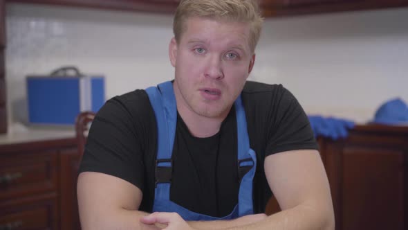 Portrait of Exhausted Caucasian Man with Red Eyes Looking at Camera. Tired Repairman