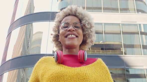 African American Woman with Headphones and with Afro Hair Looking at Camera