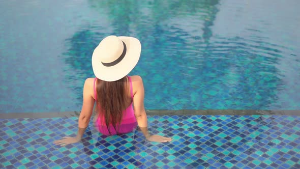 Young asian woman enjoy around outdoor swimming pool for leisure