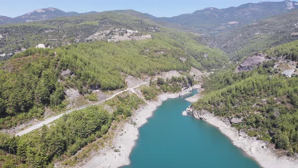 Top view on the canyon with a river in it and a road with a car driving, 4k