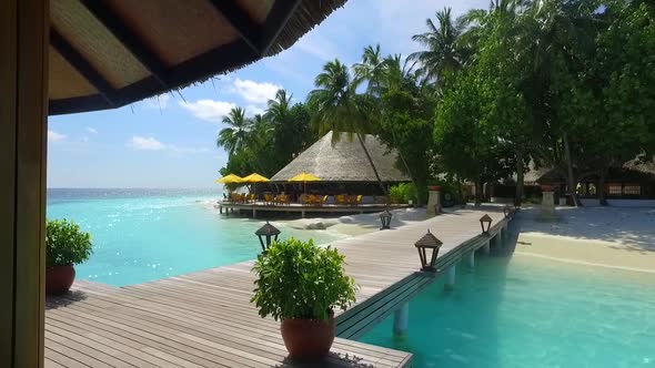 View of a tropical island dock pier over a beach.