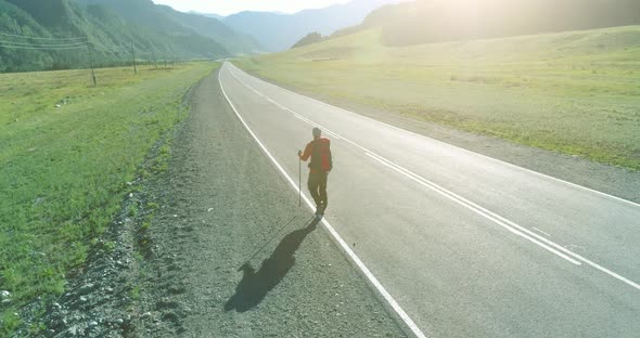 Flight Over Hitchhiker Tourist Walking on Asphalt Road