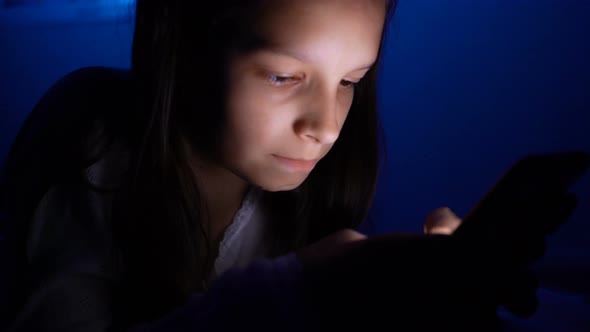 Young Girl Chatting Online with Smartphone at Night