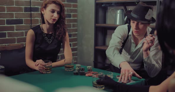 Young Man with a Hat Smokes a Cigar and Plays Poker