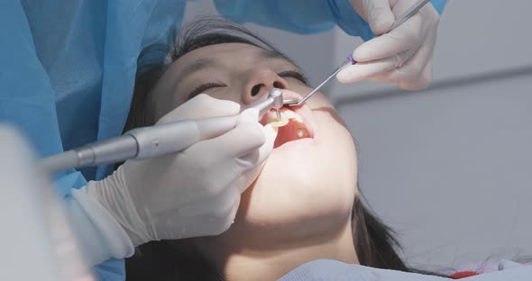 Woman undergo professional tooth whitening and ultrasound cleaning at dental clinic