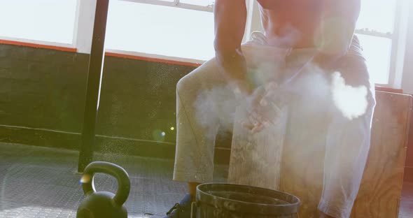 Senior man clapping white powder on his hand before workout 