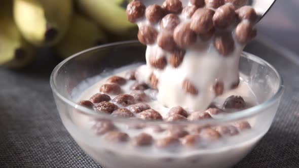 Close Up of Chocolate Corn Flakes and Milk in a Bowl on Table