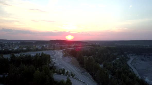 Orange Sun Sets Over Small Town at Outdated Mining Sector