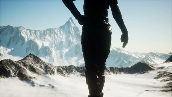 Woman Standing In Snow Wearing Warm Clothes In Mountains