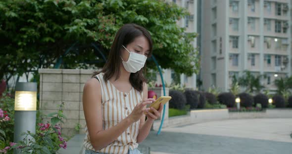 Woman wear face mask and use of mobile phone at outdoor