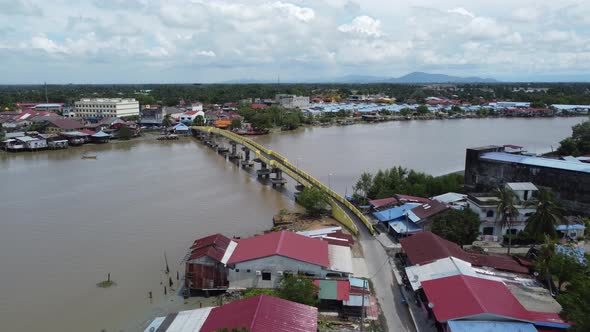 Aerial fly toward yellow pedestrian bridge cross river