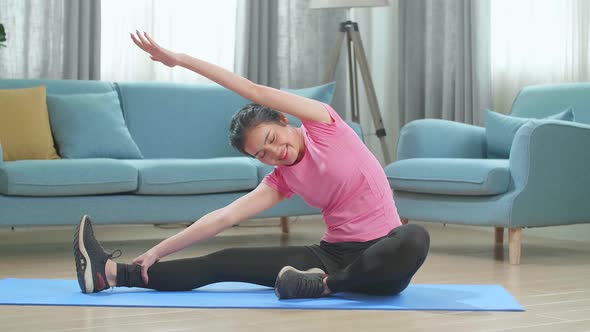 Asian Beautiful Fitness Woman Is Doing Stretching Yoga Exercises In Her Living Room