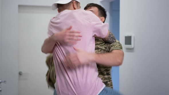 Happy Gay Soldier Returning Home As Boyfriend Jumping on Hips Hugging Lover Smiling