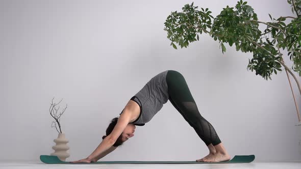 An Adult Slender Woman Practices Classical Yoga Asanas