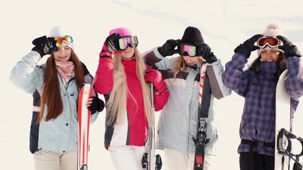 Women Snowboarders and Skiers on Mountain Slope Talking and Relaxing After Slide