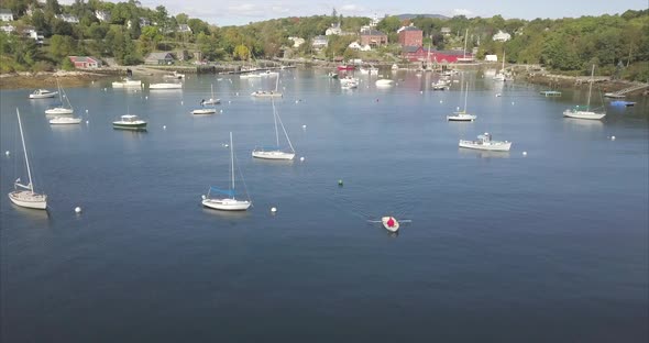 Flying over a harbor full of boats, with a rowboat heading out to sea in Rockport, Maine.